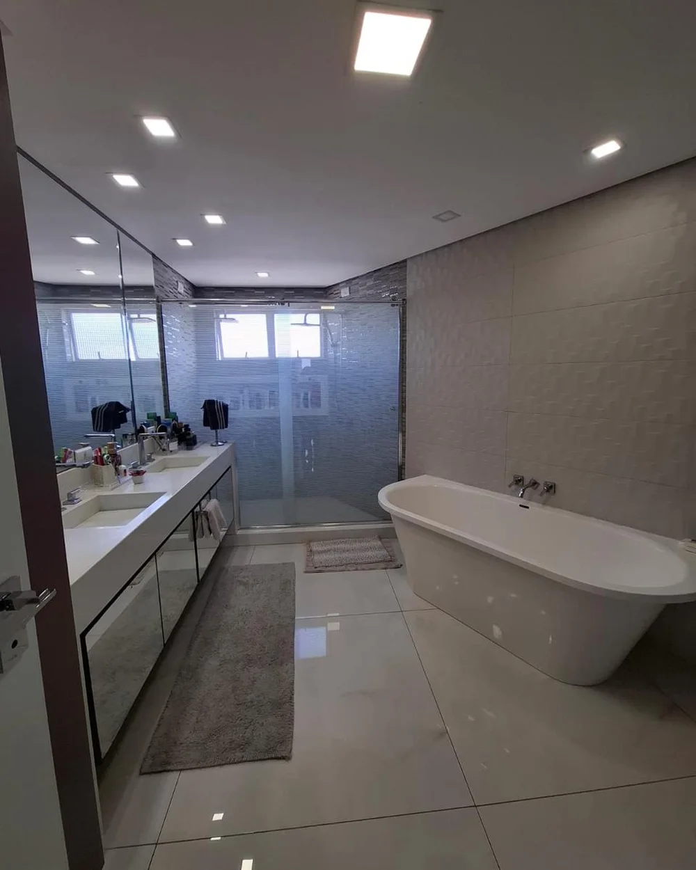 Suíte reformada com box de vidro e revestimento em porcelanato