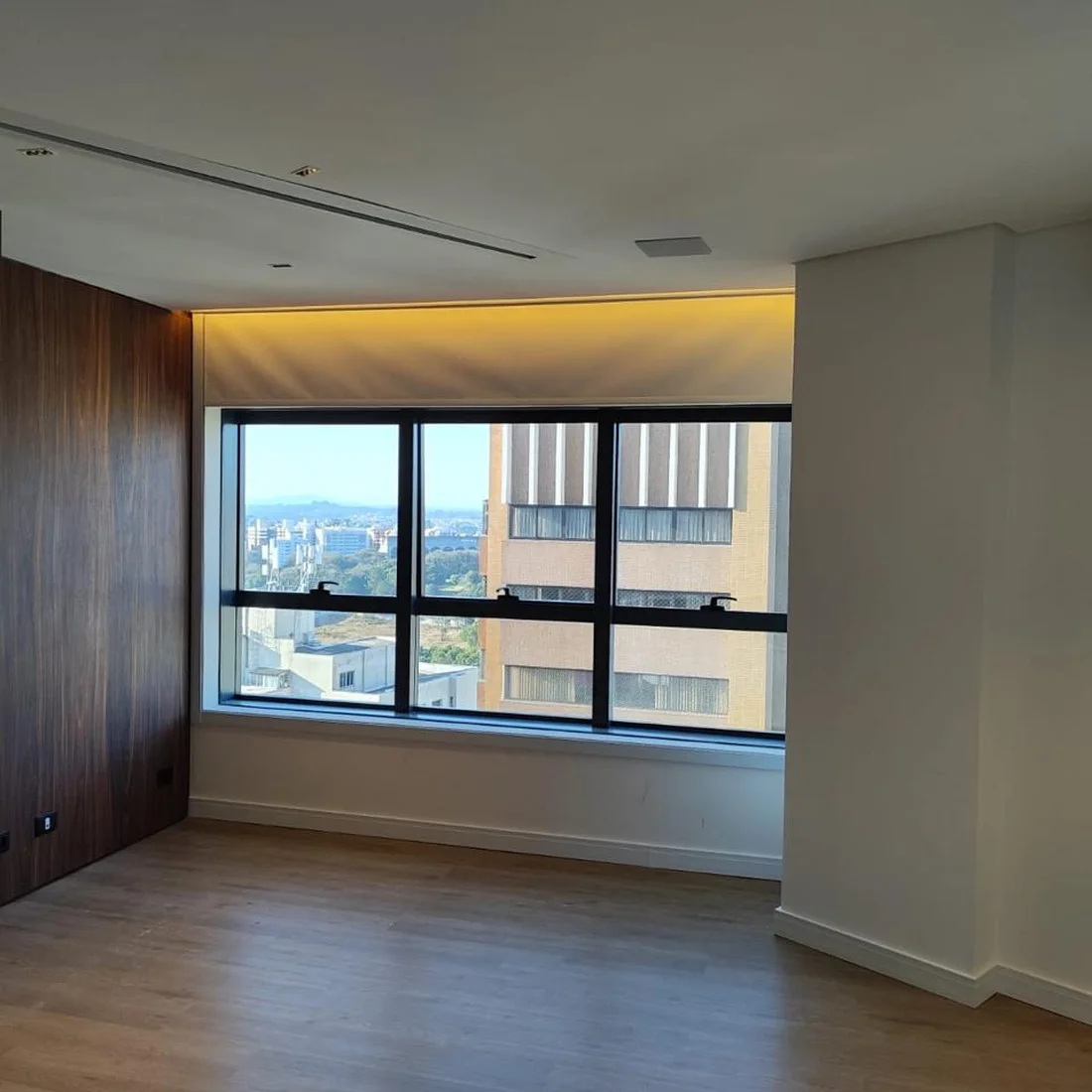 Quarto de apartamento reformado com painel de madeira e iluminação indireta